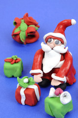 Santa Claus holding several Christmas gifts concept