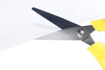 Closeup of scissors cutting a sheet of paper