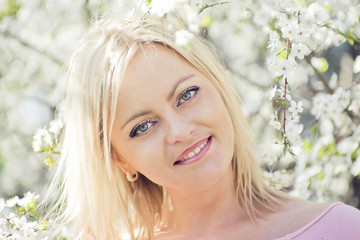 happy young blond woman in the spring garden