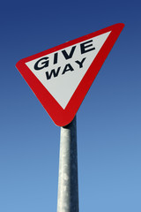 British give way road sign and a blue sky.