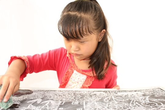 Young chinese girl drawing on a blackboard