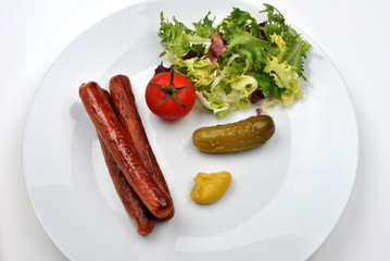 smoked sausage and organic gherkin on a plate