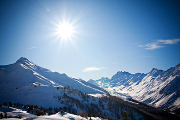 Winterlandschaft mit vielen Bergen und Sonne in Tirol 