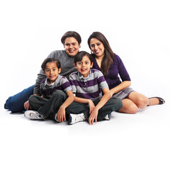 Happy smiling family of our sitting on the ground isolated