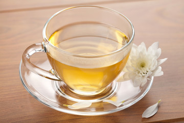 cup of green tea and white flower