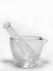 Glass mortar and pestle on white background