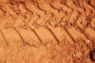 Clay red soil with tractor tires footprint
