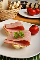 slice poppy seed bread with salami on a plate