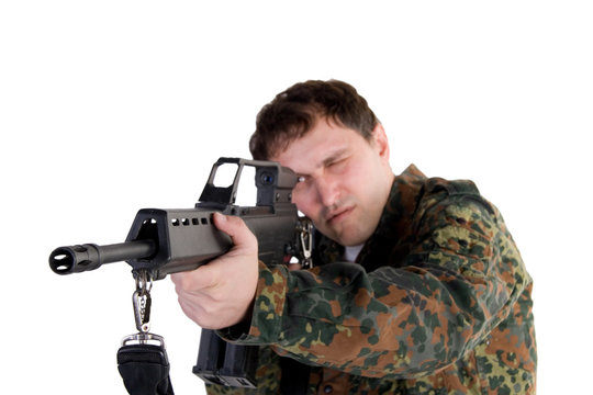 Portrait of a soldier aiming a gun (with focus on the gun)