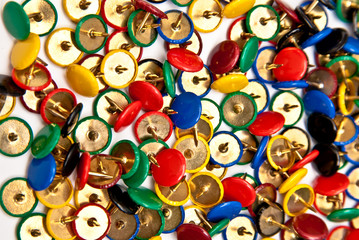 Obraz premium colorful thumbtacks goes to pieces on white background