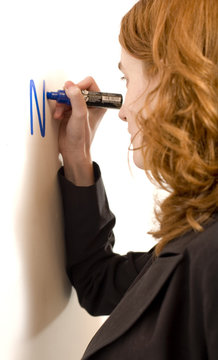 jeune femme sexy en costume ecrit au tableau blanc