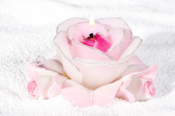 Burning candle in the form of roses.