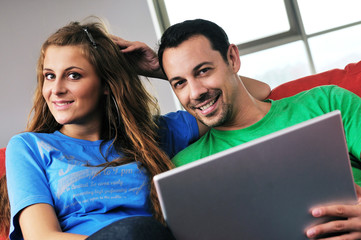 happy couple have fun and work on laptop at home