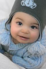 Bébé souriant avec bonnet et manteau d'hiver