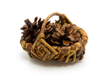 Basket with pine cones over white background
