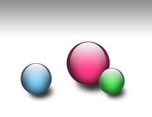 Three colored glass spheres with shadows over white