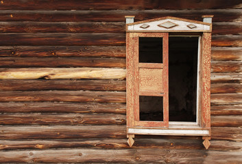 Wall of an old wooden house and the lop-sided window