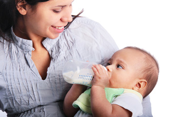 Happy mother feeding formula to baby child