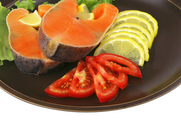 two salmon steak on dark dish
