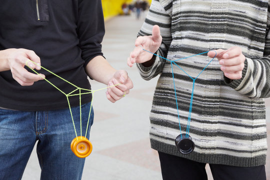 two teens with yo-yo toys in their hands. focus on clothes