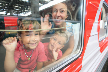 mother and children look from train window