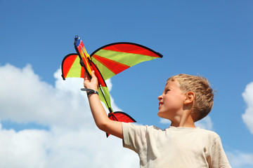 boy plays kite against sky