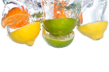Citrus fruit falling into clear water