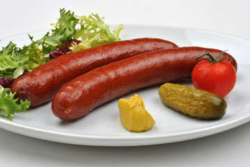 smoked sausage and organic gherkin on a plate