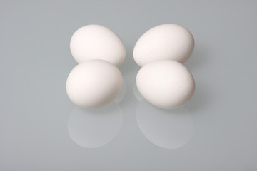 Chicken eggs on a glass table.