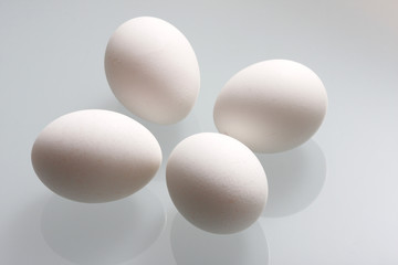 Chicken eggs on a glass table.
