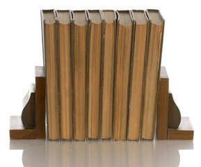 old books held up with wooden bookends with reflection