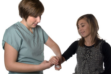 infirmière qui fait un bandage au bras d'une patiente