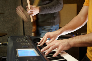 keyboard player playing in studio. guitar player in out of focus