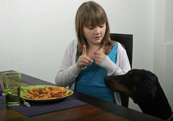 jeune fille éduquant son chien à ne pas réclamer à table
