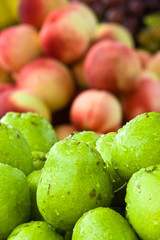 closeup of pears with peaches in background