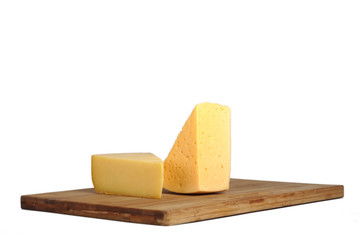 Pieces of cheese on a board.