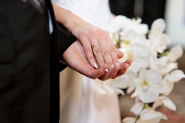 Obraz na płótnie Canvas Bride and groom holding each other's hands
