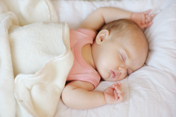 Sweet little newborn baby in a bed