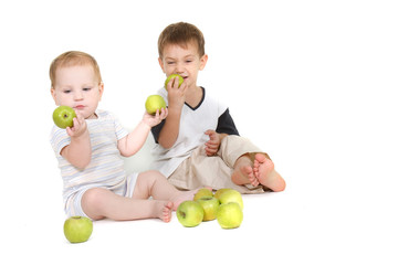 Fototapeta premium two children with green apples over white