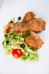 Roasted chicken legs with salad.