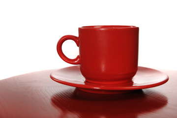 Red cup with a saucer on a red table