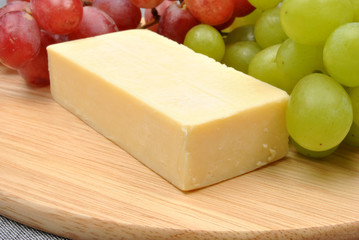 cheese and sweet grape on a timber board