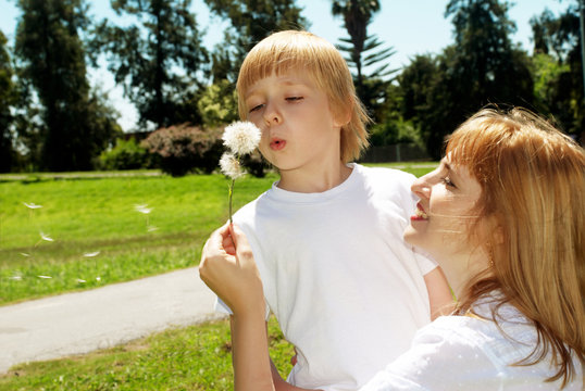 Mother with the son with dandelions in hands