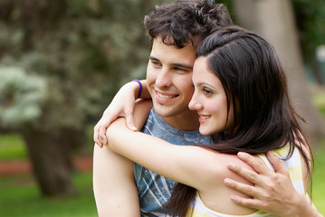 Fototapeta premium couple portrait outdoors smiling with a green background