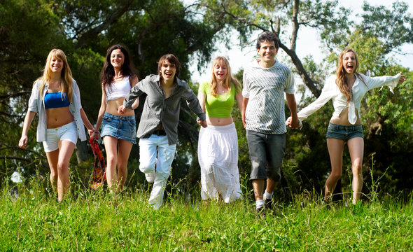Youth group running on a grass against the nature