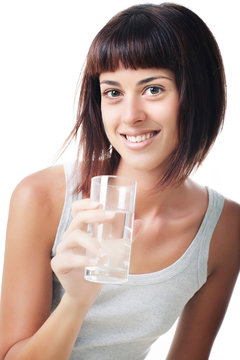Beautiful smiling young woman holding a glass of water