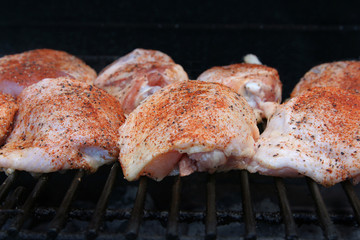 Chicken breasts broiling over an open fire