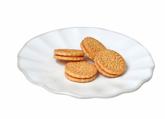 Four vanilla sandwich cookies on a white plate