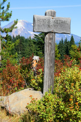 Old trail sign with Mt St. Helens in the background.