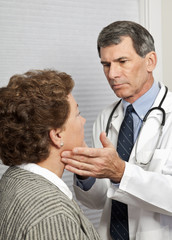 Doctor Checking Female Patient For Flu Symptoms in Office
